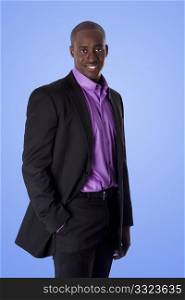 Handsome happy African American corporate business executive man smiling, wearing black suit with purple shirt, standing with authority with hand in pocket, isolated.
