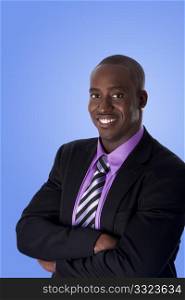 Handsome happy African American corporate business man smiling, wearing black suit with purple shirt, arms crossed, isolated.