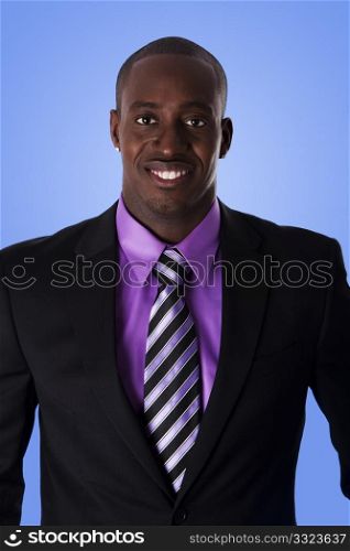 Handsome happy African American corporate business man smiling, wearing black suit with purple shirt and striped necktie, isolated.