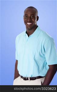 Handsome happy African American corporate business man smiling, wearing blue polo shirt, hands in pocket, standing, isolated.