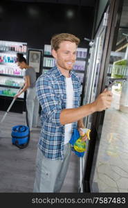 handsome happy man cleans the windows