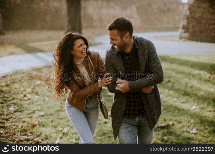Handsome happy young couple walking in autumn park
