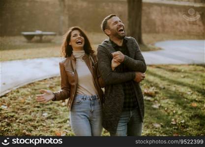 Handsome happy young couple walking in autumn park