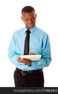 Handsome happy young male corporate MBA business student in blue shirt and black tie writing ideas notes on notepad, isolated.