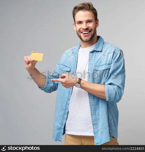 Handsome happy young man showing blank bank cor discount card.. Handsome happy young man showing blank bank cor discount card