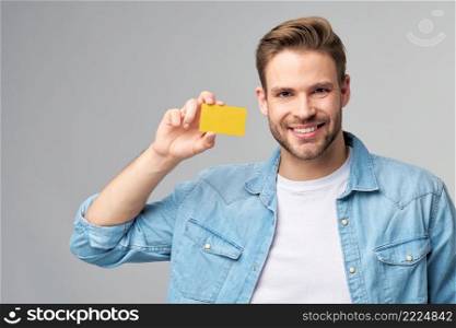 Handsome happy young man showing blank bank cor discount card.. Handsome happy young man showing blank bank cor discount card