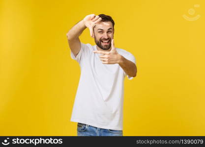 Handsome Irish redhead man with beard wearing glasses over yellow isolated background smiling making frame with hands and fingers with happy face. Handsome Irish redhead man with beard wearing glasses over yellow isolated background smiling making frame with hands and fingers with happy face.