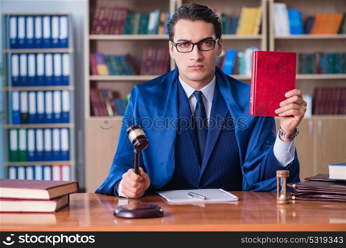 Handsome judge with gavel sitting in courtroom