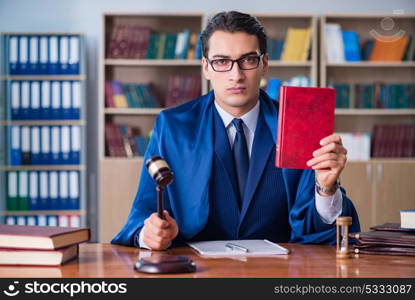 Handsome judge with gavel sitting in courtroom