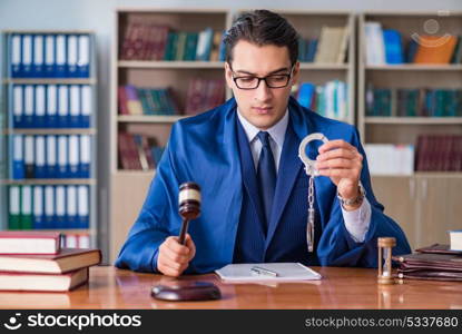 Handsome judge with gavel sitting in courtroom