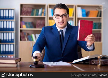 Handsome judge with gavel sitting in courtroom