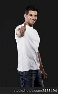 Handsome latin man with thumbs up, isolated over a dark background