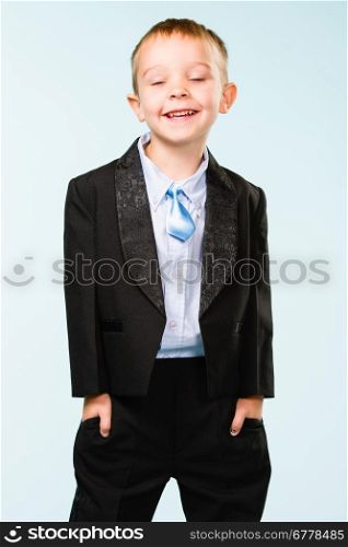 Handsome little boy posing on studio, light blue background