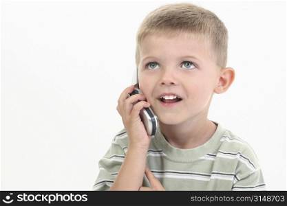 Handsome little four year old boy speaking on cellphone.