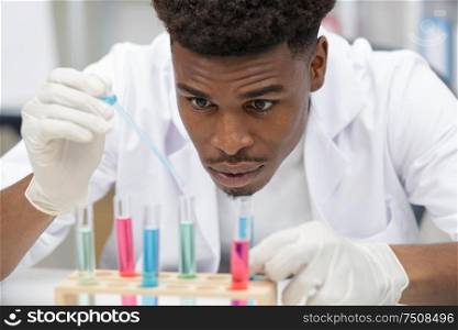 handsome male lab technician concentrating doing medical research