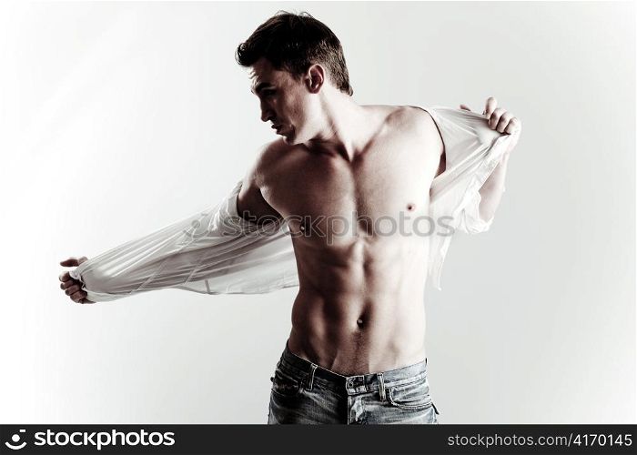 Handsome male model taking off his shirt