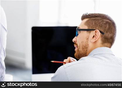 Handsome male worker in office. Handsome businessman in office in front of computer