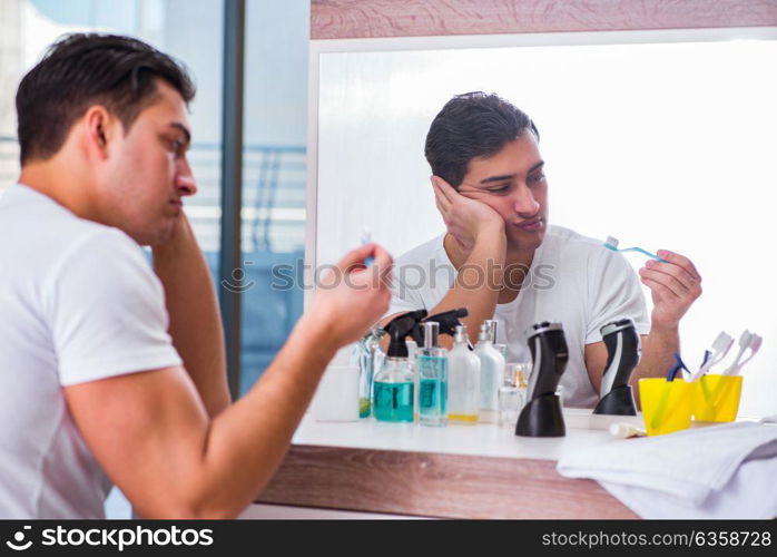 Handsome man brushing teeth in the morning