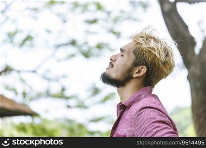 Handsome man deep breath close an eyes relaxation at the park. take a deep breath and feel happiness resting and happy