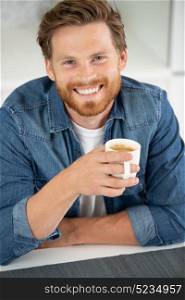 handsome man drinks coffee at home