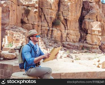 Handsome man, exploring the sights of the ancient, fabulous city of Petra in Jordan. Colorful photos. Concept of leisure, vacation and travel. Handsome man, exploring the sights of of Petra