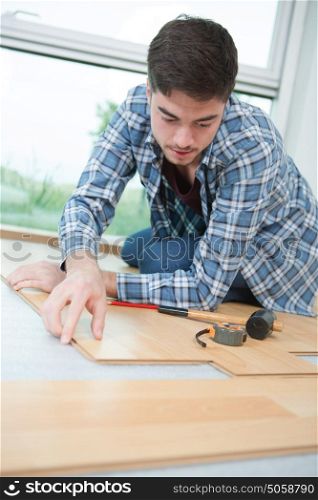 handsome man fitting a wooden plank