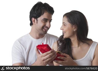 Handsome man gifting bangles to woman against white background