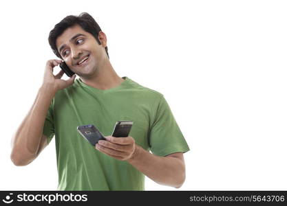 Handsome man holding cell phones while on call