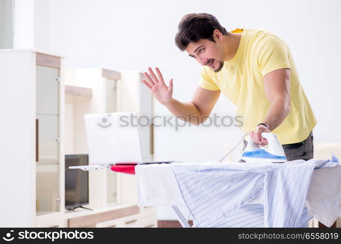 Handsome man husband doing clothing ironing at home