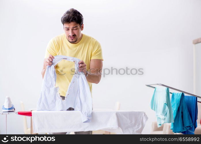 Handsome man husband doing clothing ironing at home