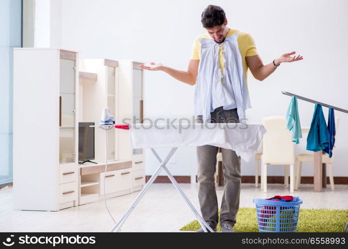 Handsome man husband doing clothing ironing at home