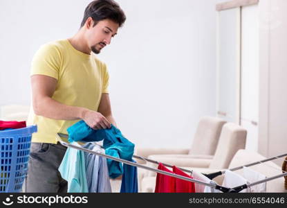 Handsome man husband doing laundering at home