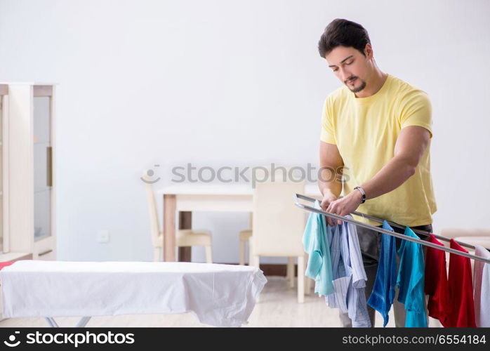 Handsome man husband doing laundering at home