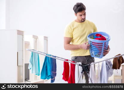 Handsome man husband doing laundering at home