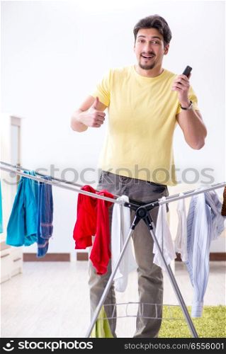 Handsome man husband doing laundering at home