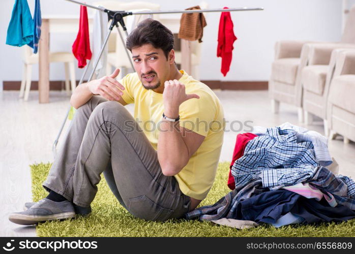 Handsome man husband doing laundering at home