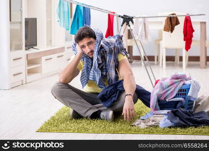 Handsome man husband doing laundering at home