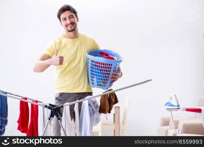 Handsome man husband doing laundering at home