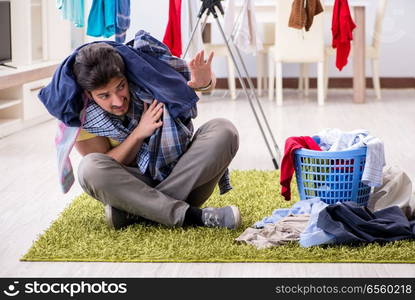 Handsome man husband doing laundering at home