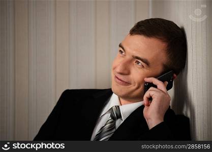 Handsome man in black suit with cell phone talking