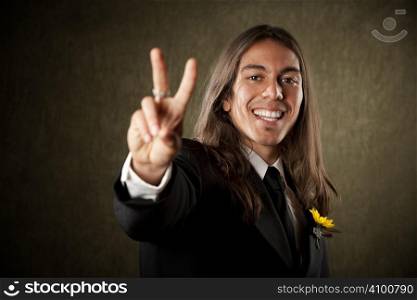 Handsome man in formal jacket with boutonniere making peace sign