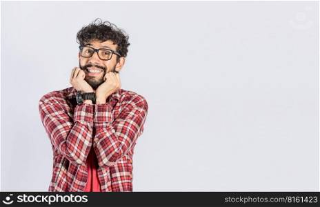 Handsome man in glasses smiling kindly, close up of smiling man touching his cheeks on isolated background, face of smiling friendly guy with hands on cheek
