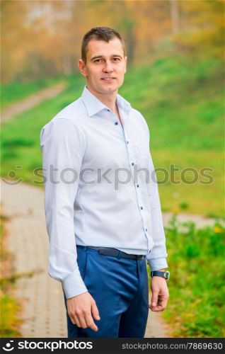 handsome man in shirt and trousers smiling