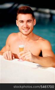 Handsome man in the pool toasting with champagne relaxed