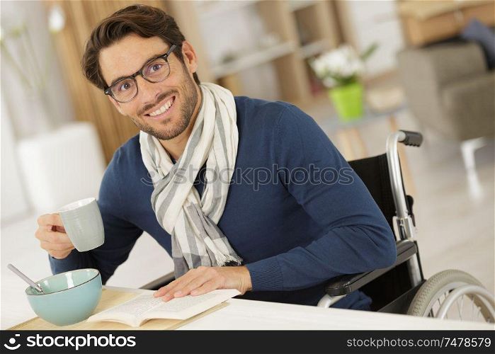 handsome man in wheelchair drinking coffee