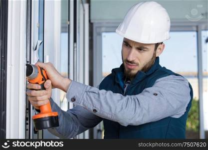 handsome man installs a window handle