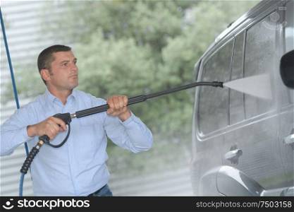 handsome man is cleaning car outdoor