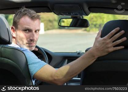 handsome man is driving in reverse