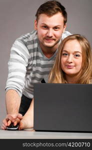 handsome man is helping woman to work wirh laptop