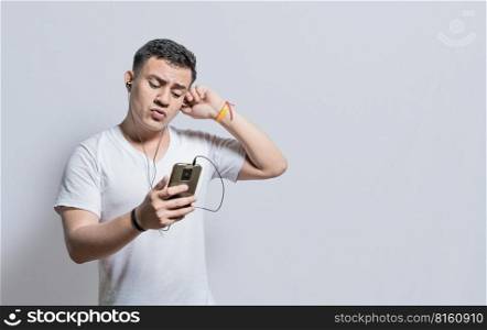 Handsome man listening to music with his cell phone with headphones isolated, people enjoying music with headphones isolated, cheerful guy listening to music with his cell phone isolated